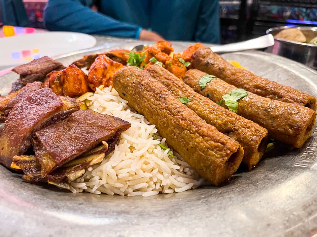 a plate filled with rice and meat srinagar trip