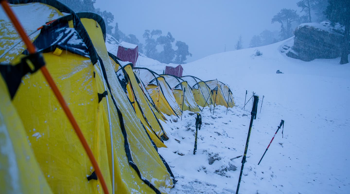 yellow tents surrounded with white snow winter trek