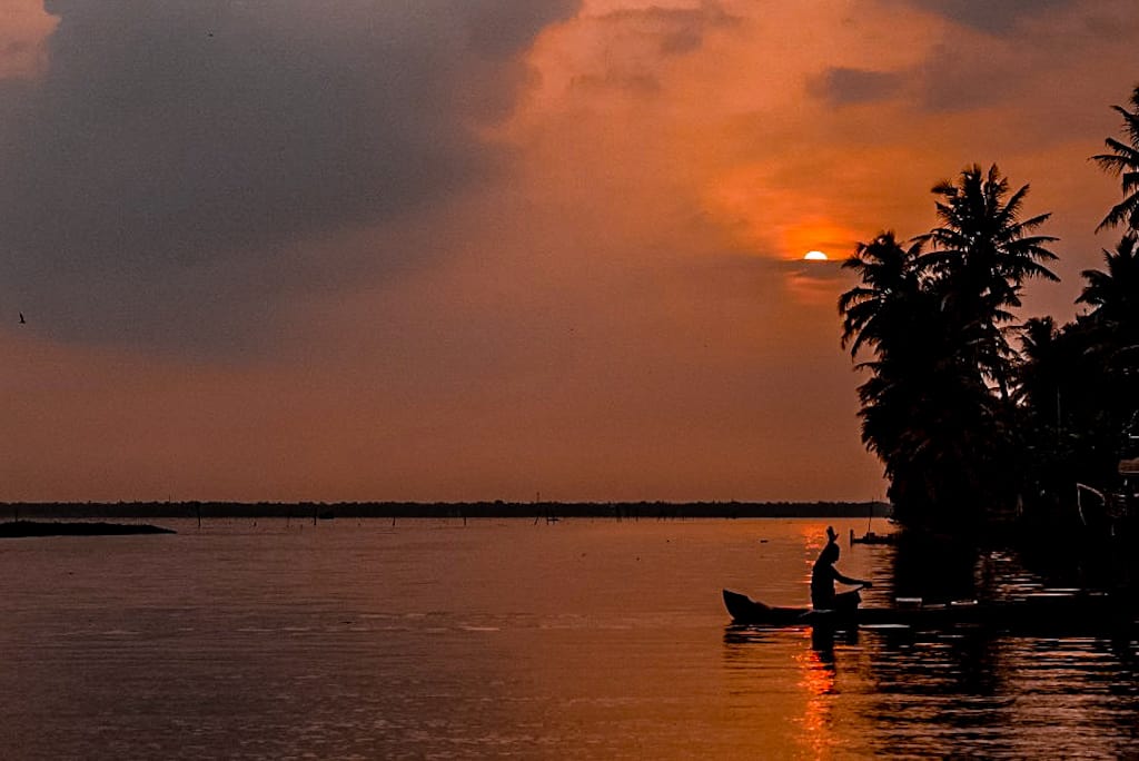 Mam rowing a boat during sunset things to do in Alleppey