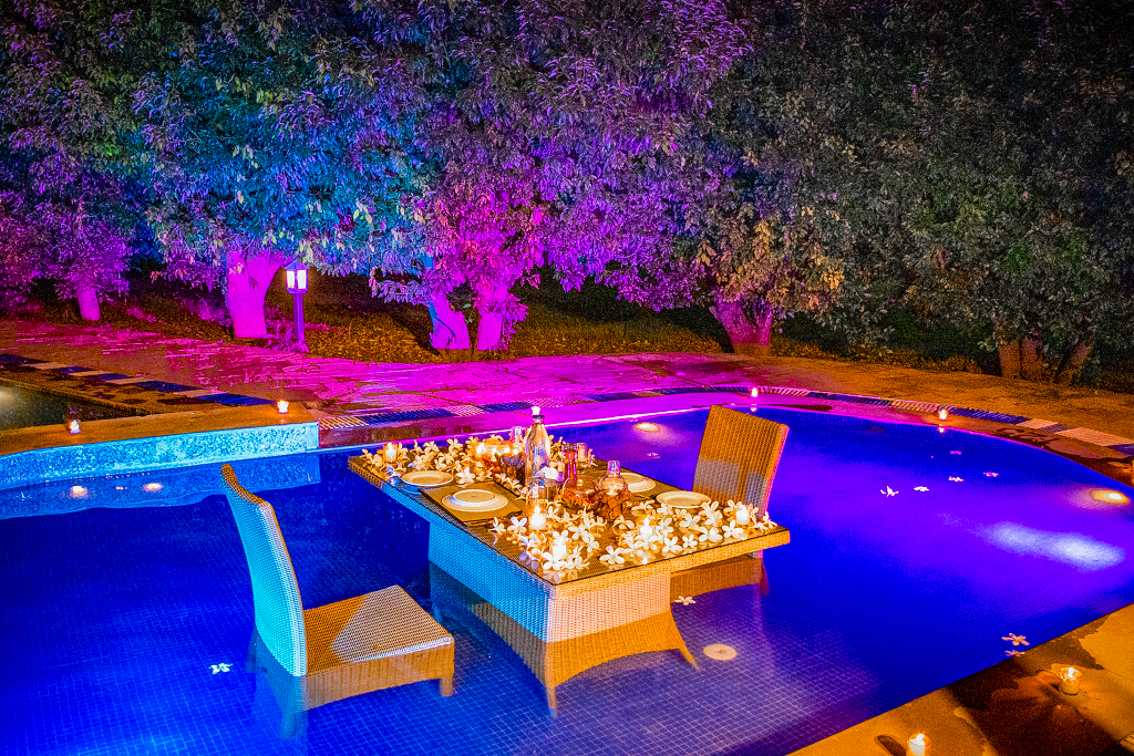 table setting in a swimming pool with candlelight golden tusk jim corbett