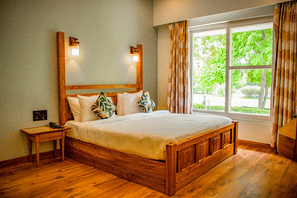 spacious room with a double bed and window overlooking the garden golden tusk jim corbett
