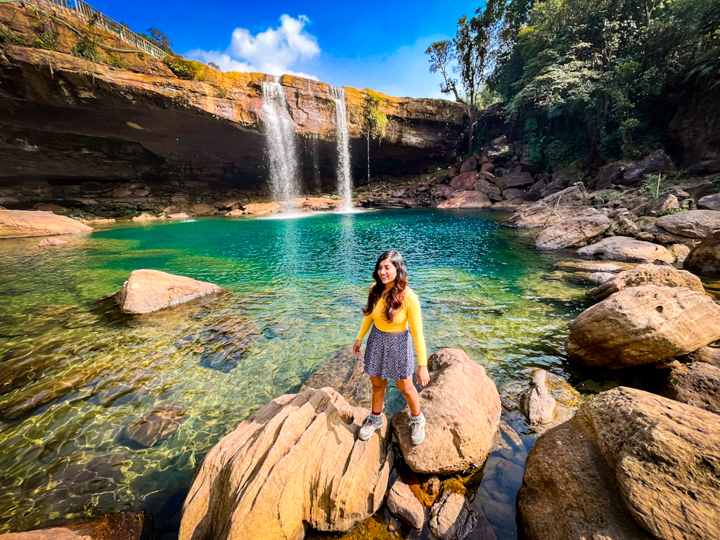 girl standing beside a waterfal digital nomad