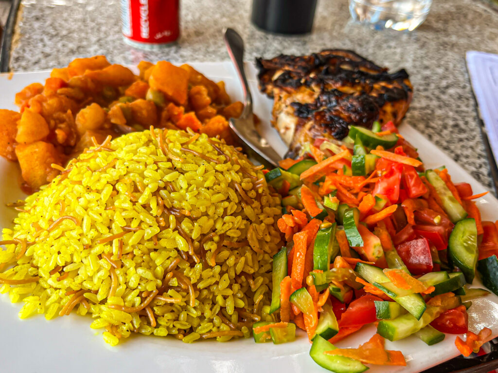 rice with veggies and BBQed chicken on a plate